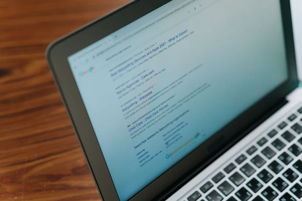 A physical laptop displaying a web search page.