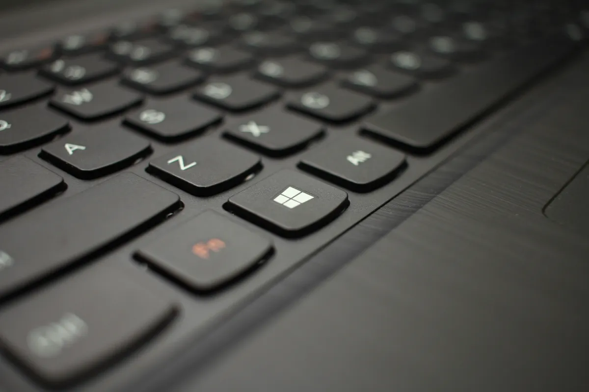 Close-up photograph of a black laptop keyboard with the Windows key in focus.