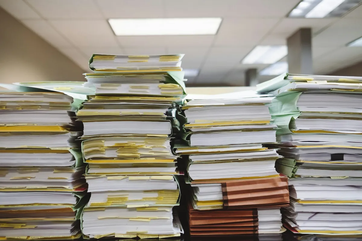 Stacks of paper records and document folders in an office.