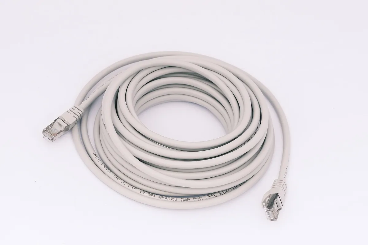 A pale gray Ethernet cable coiled on a white background, with both transparent plugs visible.