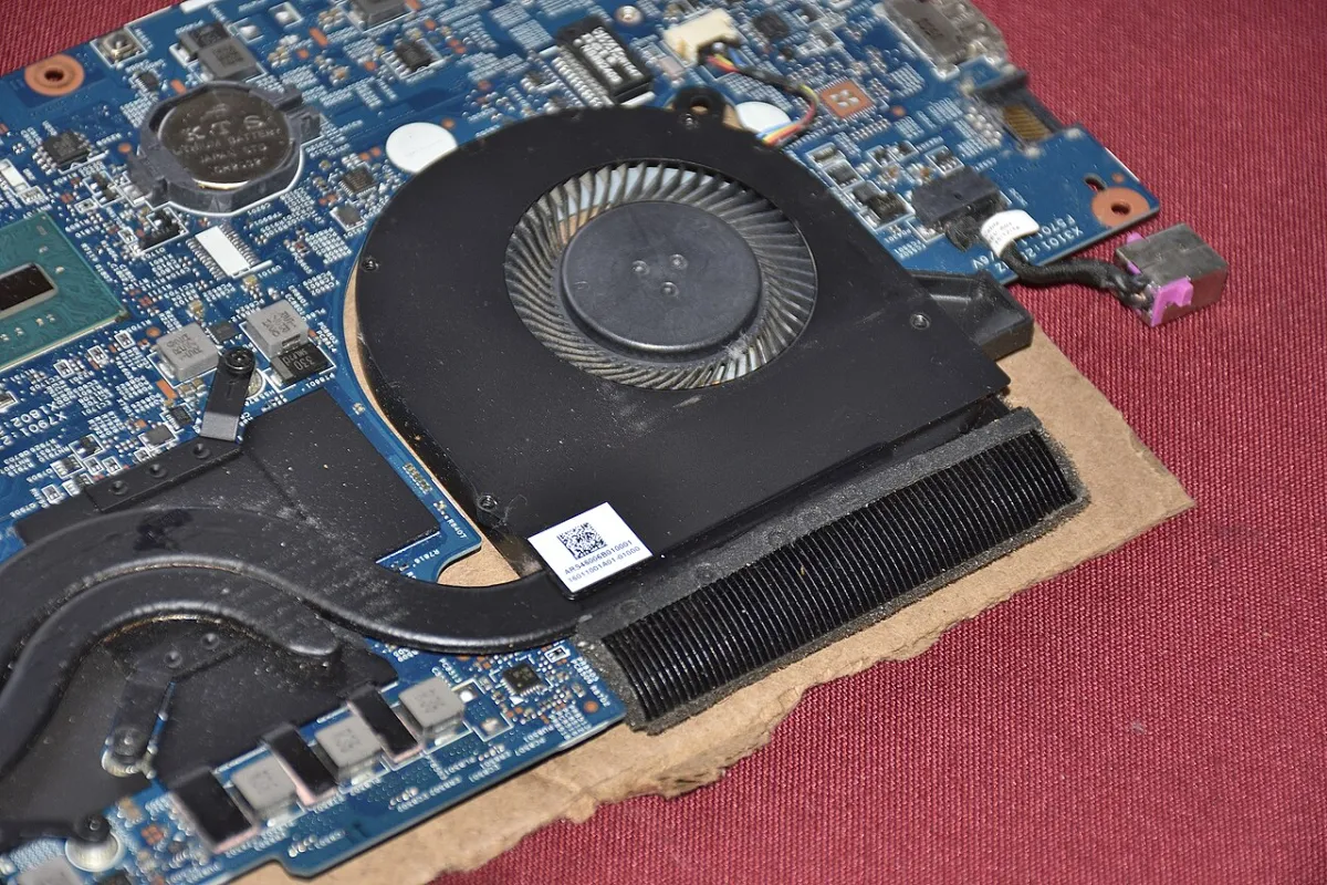 A laptop cooling fan and finned heatsink mounted on a circuit board